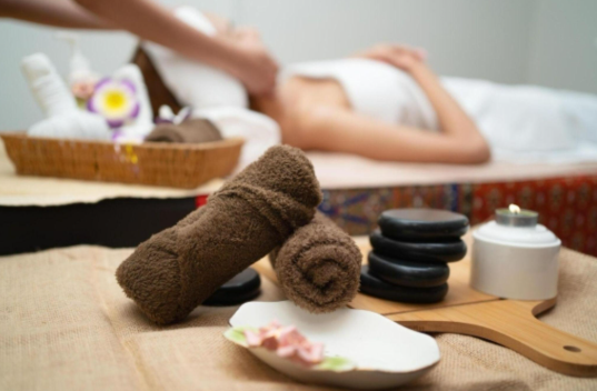 A woman receiving a relaxing facial treatment as part of a full body session in a serene spa setting.